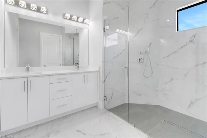 Bathroom featuring a shower with door and vanity