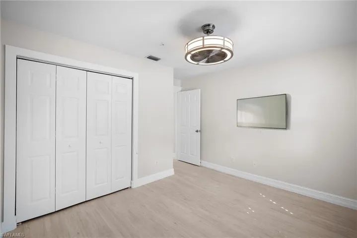 Unfurnished bedroom with light wood finished floors and a closet