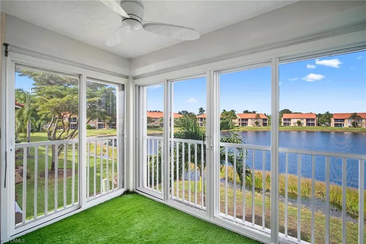 Unfurnished sunroom featuring a water view, plenty of natural light, and carpet flooring