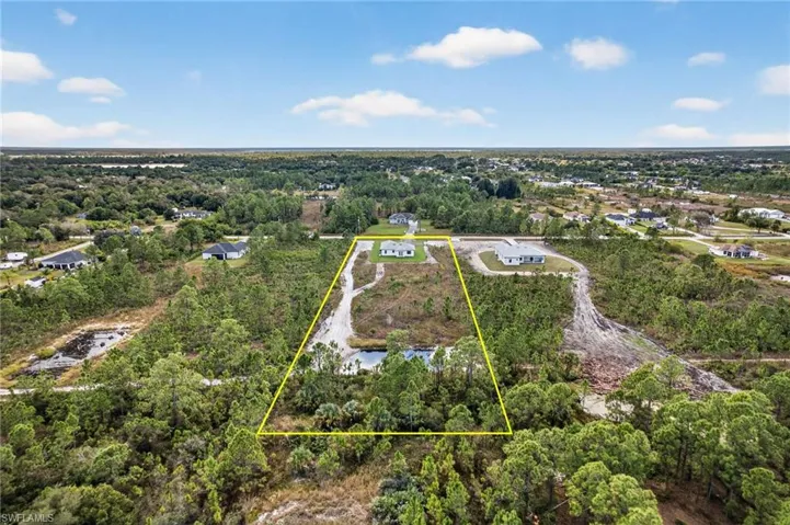Aerial overview of property's location with property parcel outlined and a heavily wooded area