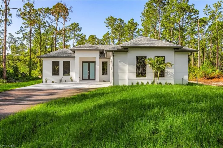 Back of property featuring french doors, a yard, and stucco siding