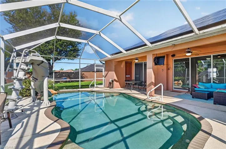 Screened-in pool deck featuring a curved pool, integrated steps, and direct access to the interior through sliding glass doors