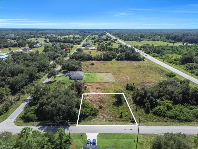Aerial view of property and surrounding area with property parcel outlined