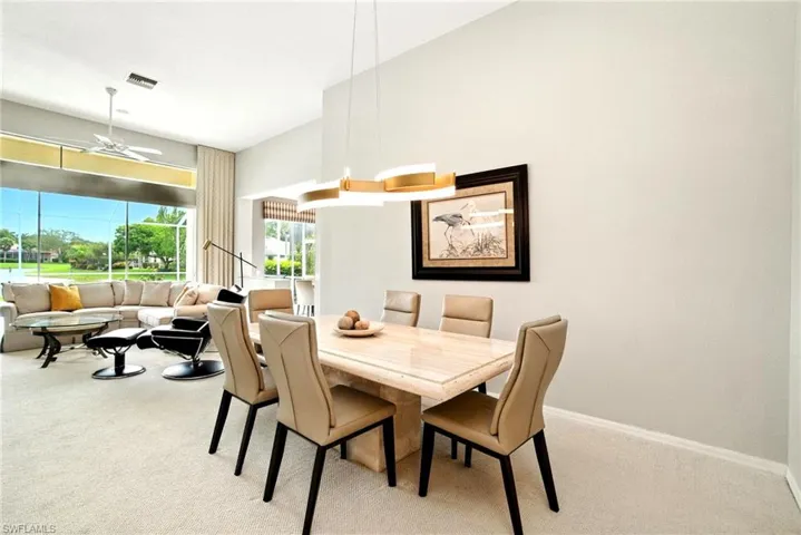 Dining area with light colored carpet and a ceiling fan