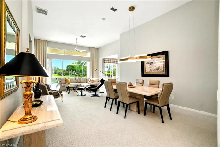 Dining area with light colored carpet and ceiling fan