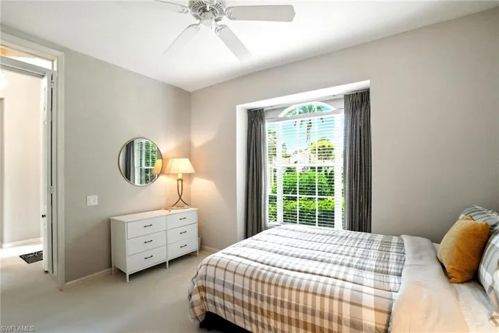 Carpeted bedroom with a ceiling fan and baseboards