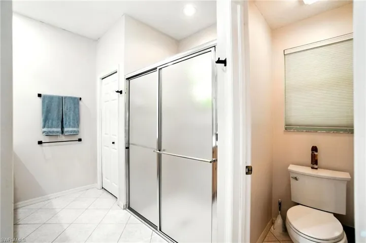 Bathroom featuring a shower stall and light tile patterned floors