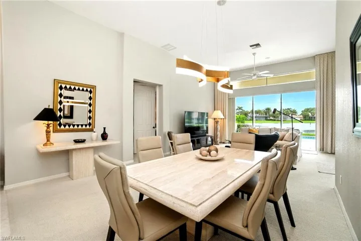 Carpeted dining space with baseboards and a ceiling fan