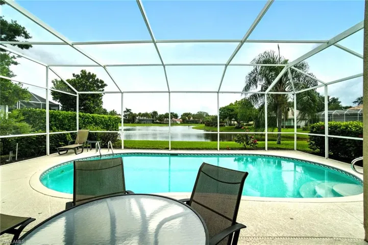 Swimming pool with a water view, a sunroom, a lanai, a patio area, and outdoor dining area