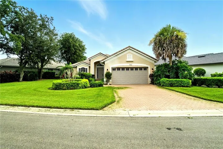 Single story home with decorative driveway, a garage, stucco siding, a front yard, and a tile roof