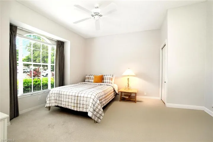 Bedroom featuring light colored carpet, ceiling fan, and a closet