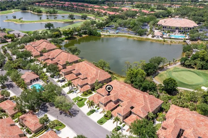 Drone / aerial view with a water view, view of golf course, and a residential view