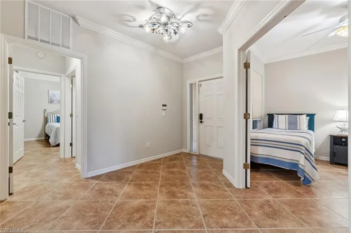 Bedroom featuring visible vents, ornamental molding, baseboards, and light tile patterned floors