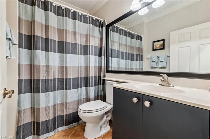 Full bath featuring crown molding, tile patterned flooring, vanity, toilet, and a shower with curtain