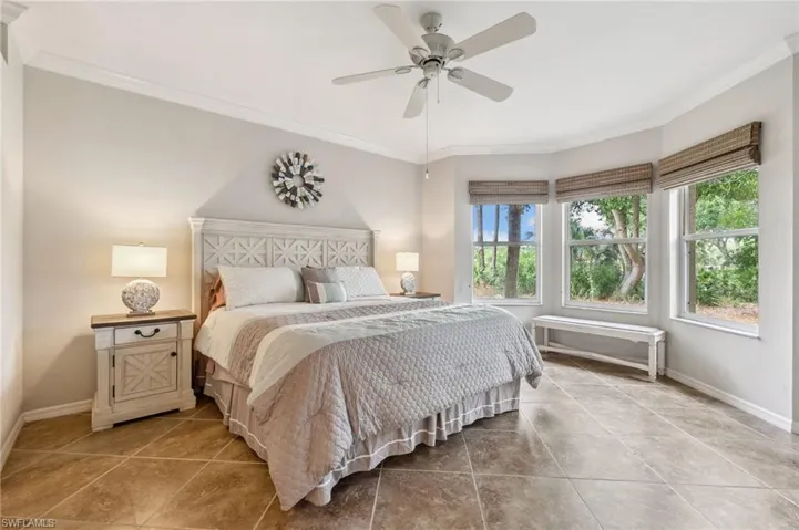Tiled bedroom with crown molding, a ceiling fan, and baseboards