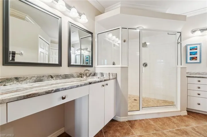 Full bath with crown molding, vanity, and a shower stall