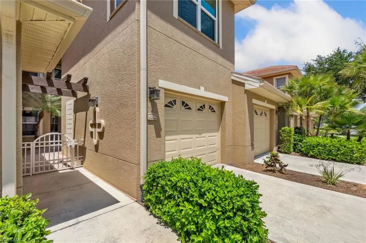 View of home's exterior with a garage, a gate, stucco siding, and driveway