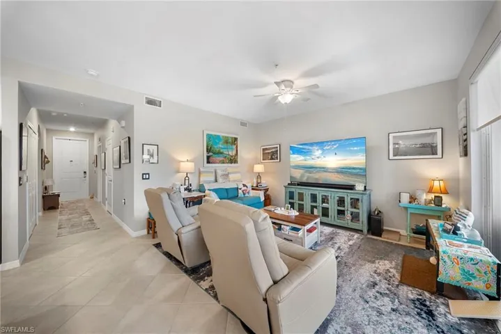 Living room with ceiling fan and light tile patterned floors