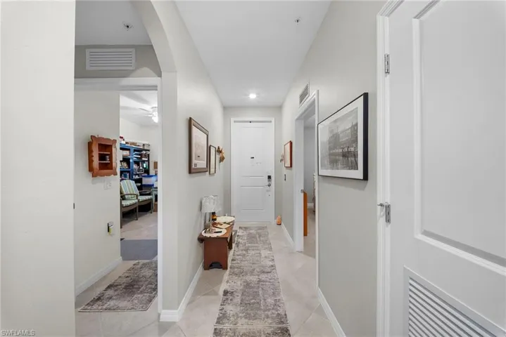 Corridor with arched walkways and light tile patterned flooring