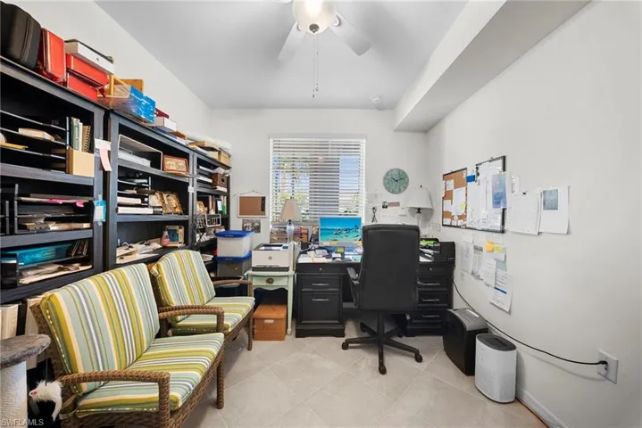 Office space with a ceiling fan and light tile patterned floors