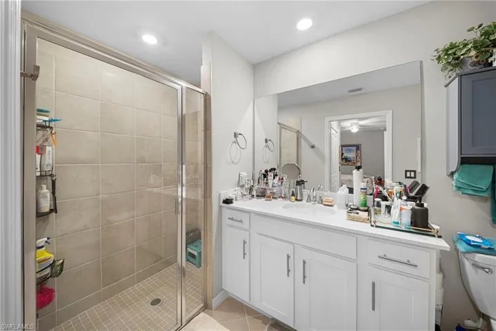 Bathroom with vanity, a shower stall, light tile patterned floors, and recessed lighting