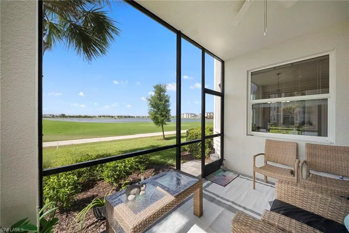 Sunroom with ceiling fan, a water view, and view of golf course