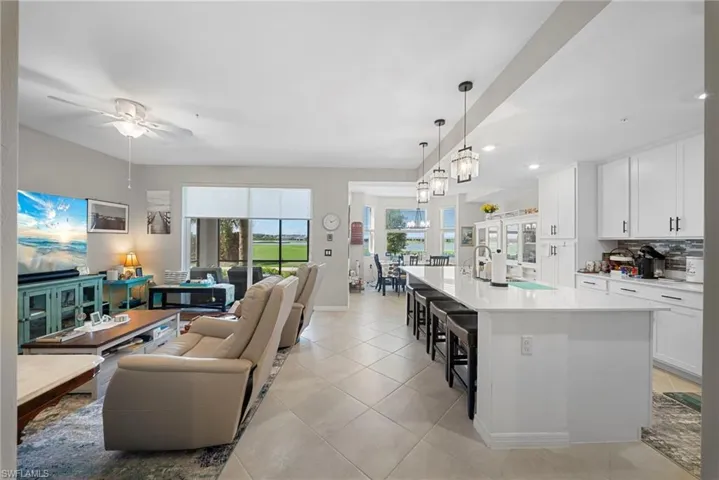 Living area featuring a ceiling fan and light tile patterned flooring