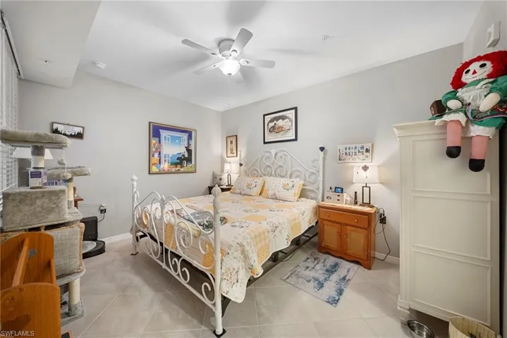 Bedroom with ceiling fan and light tile patterned flooring