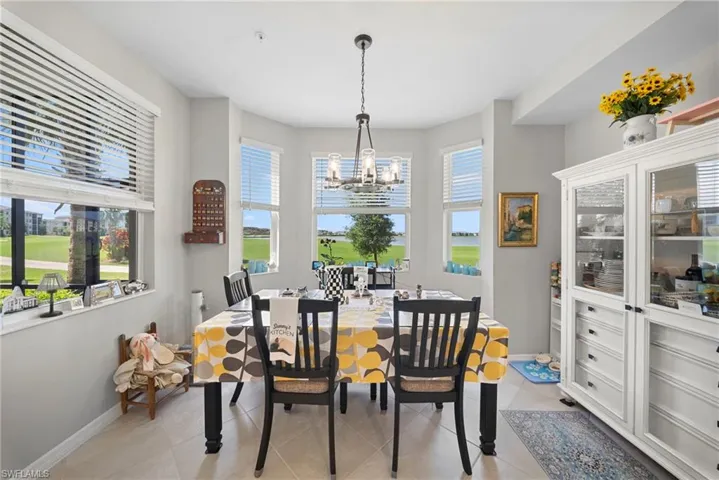 Dining space with light tile patterned floors and a chandelier