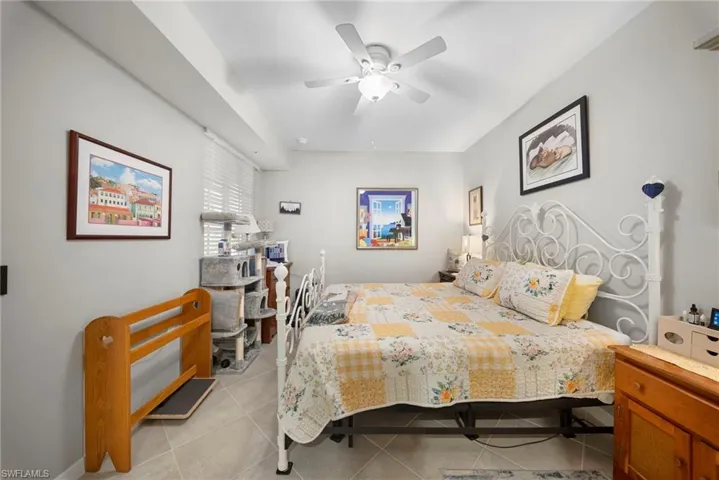Bedroom with light tile patterned floors and a ceiling fan