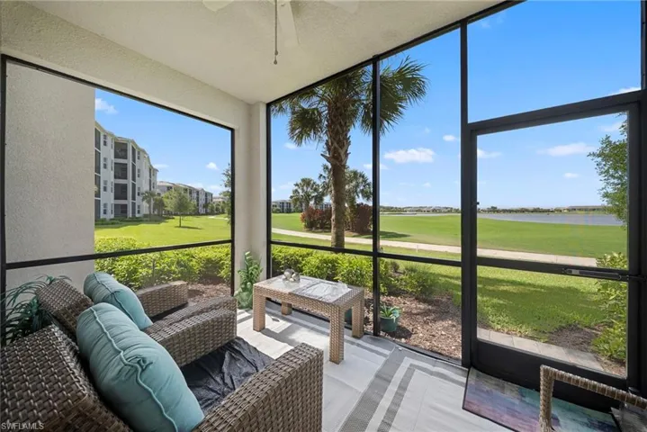Sunroom / solarium with a ceiling fan, a water view, and view of golf course