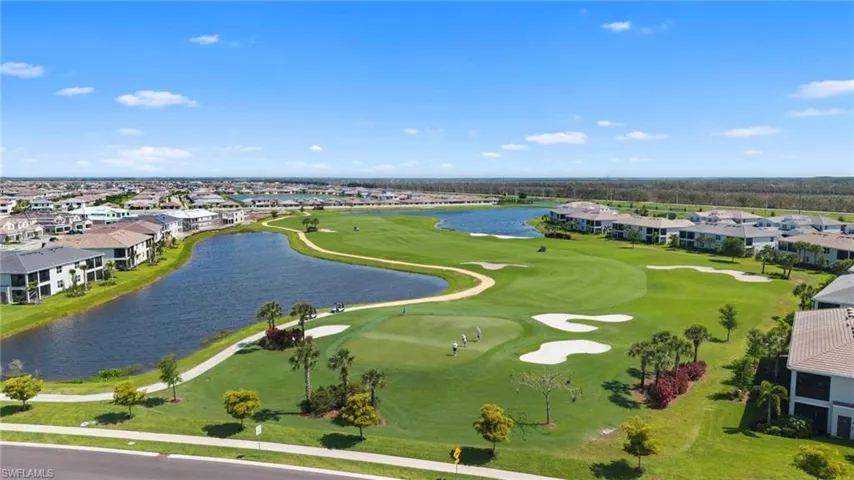 Aerial view of residential area featuring a local golf course and a large body of water