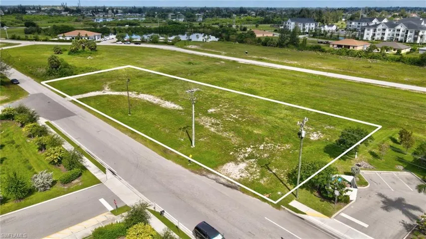 Aerial perspective of suburban area featuring property boundaries highlighted and a large body of water