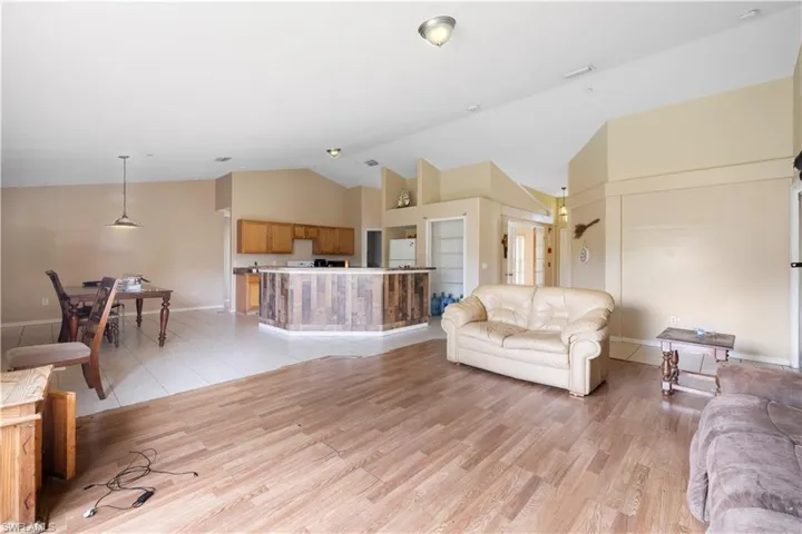 Tiled living room featuring high vaulted ceiling