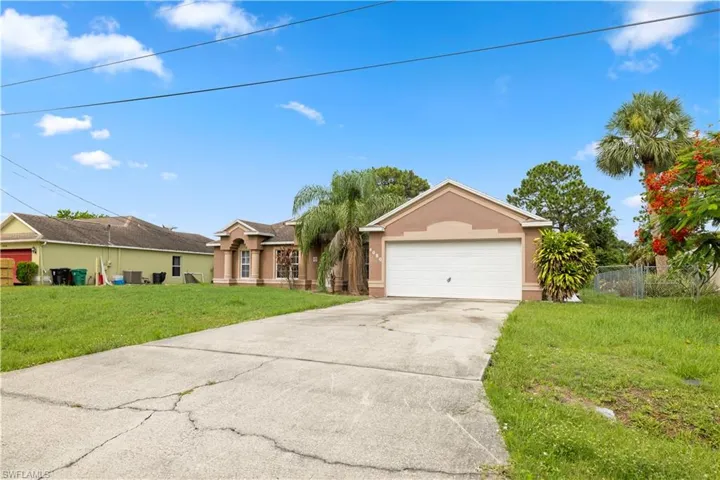 Single story home with a garage and a front yard