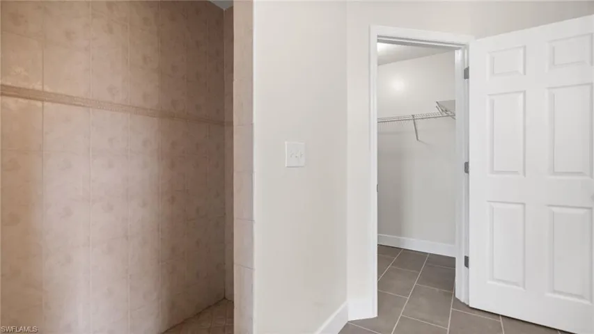 Bathroom with walk in shower and tile patterned flooring