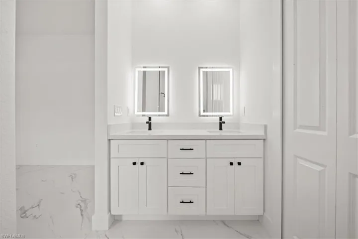 Bathroom with marble look tiles and double vanity