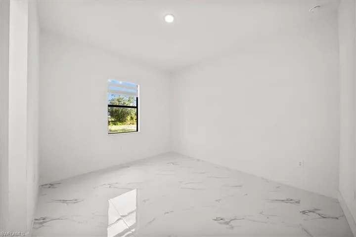 Unfurnished room featuring marble tiled flooring, a smoke detector, and recessed lighting