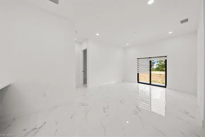 Spare room featuring marble tiled flooring and recessed lighting