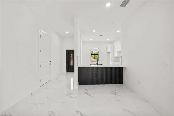 Unfurnished living room featuring recessed lighting and light marble finish floors