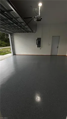 Garage featuring a garage door opener and electric panel