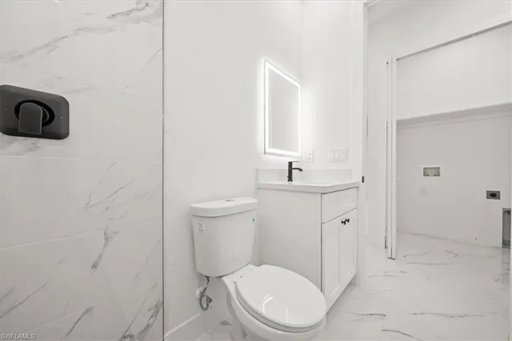 Bathroom featuring marble finish floors and vanity