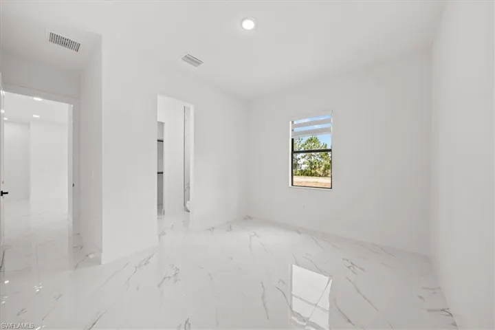 Spare room featuring marble tiled floors and recessed lighting