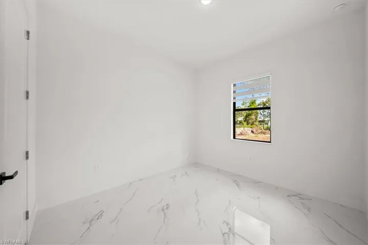 Empty room with marble tiled flooring and recessed lighting