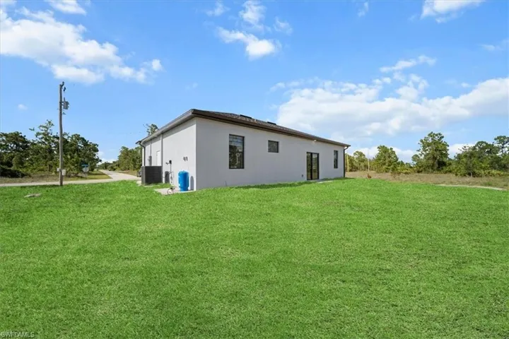 Rear view of property with stucco siding and a yard