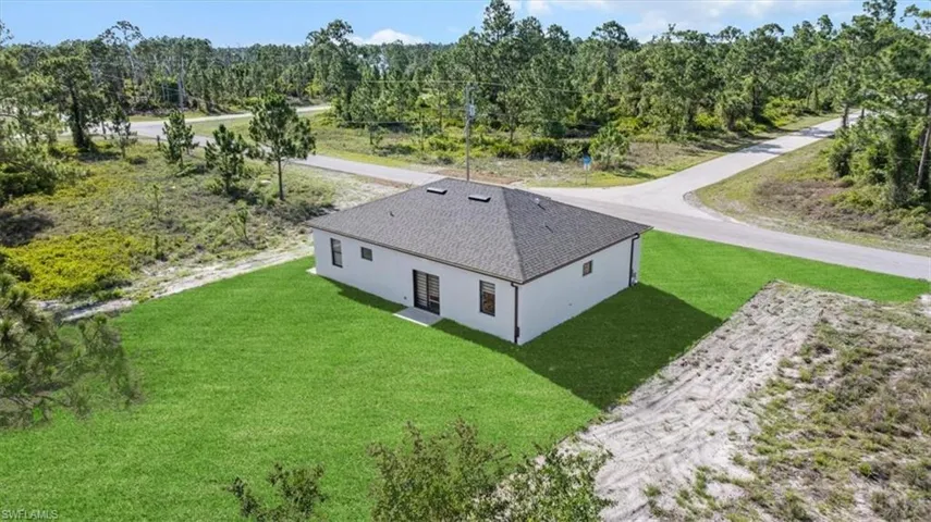 Aerial view of property and surrounding area with a forest
