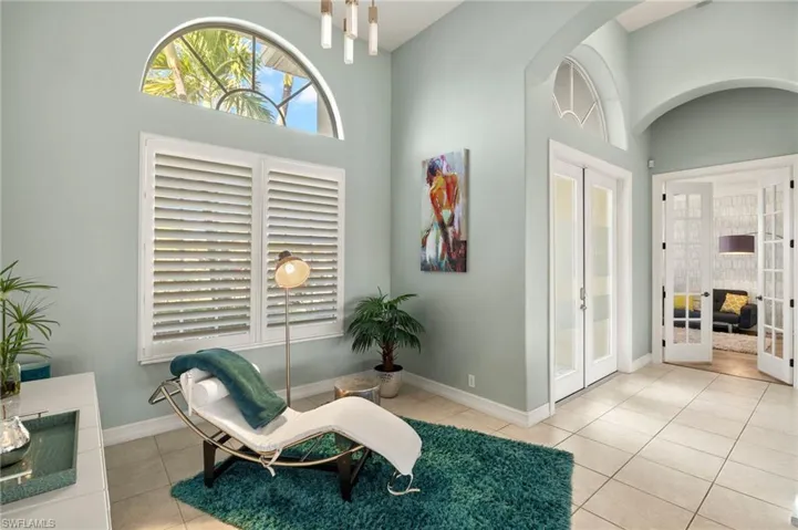 Living area featuring light tile patterned flooring and french doors