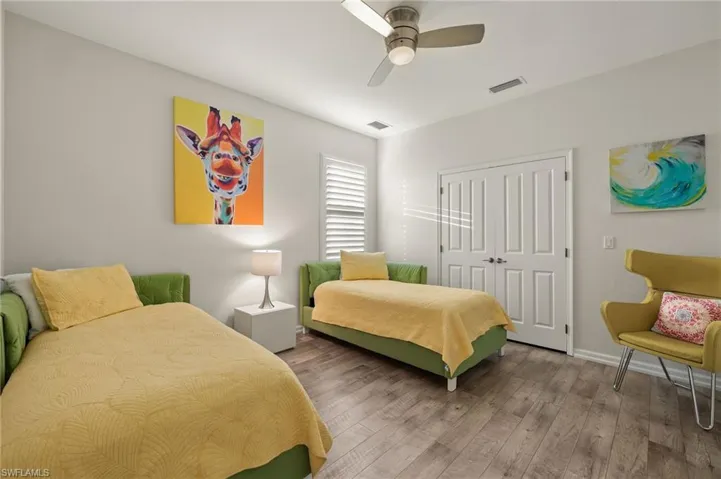 Bedroom with ceiling fan, a closet, and hardwood / wood-style flooring