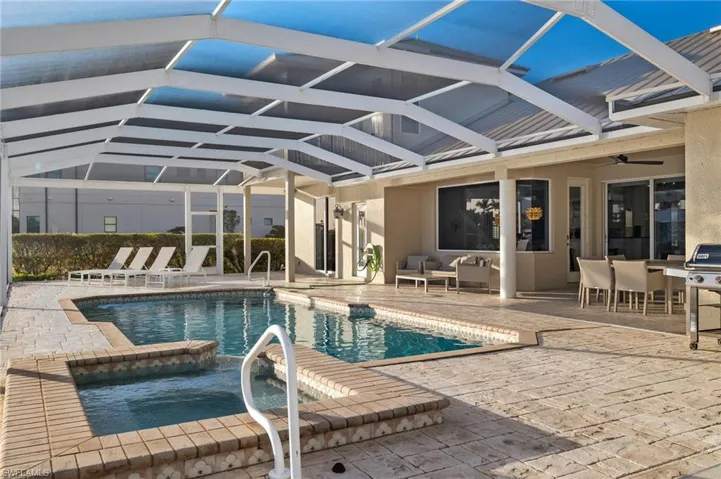 View of swimming pool with a patio, ceiling fan, a lanai, and grilling area
