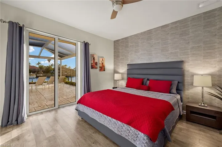 Bedroom with access to exterior, wood-type flooring, and ceiling fan